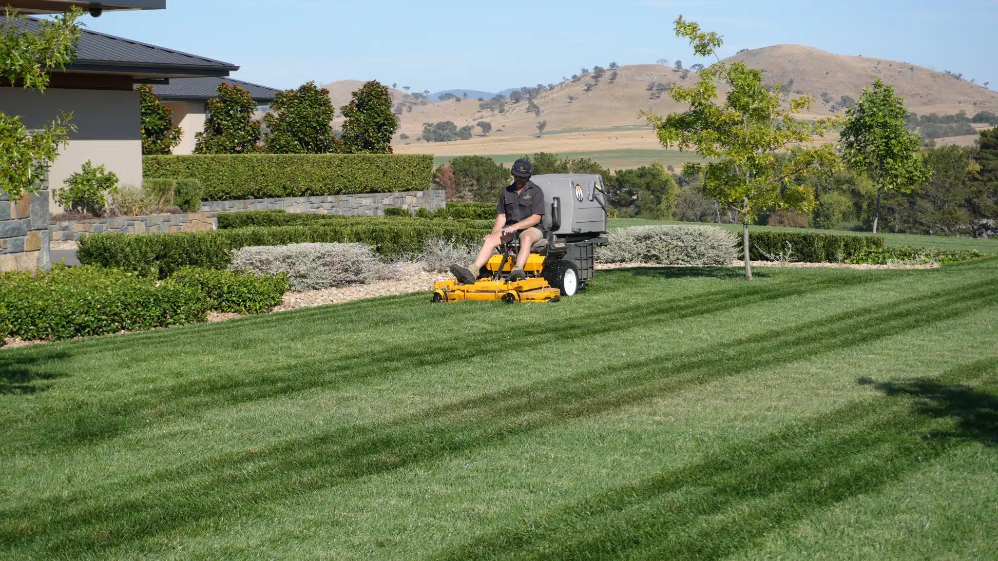 Walker Mower Caring For A Landscaped Home Lawn With Country Hills Beyond