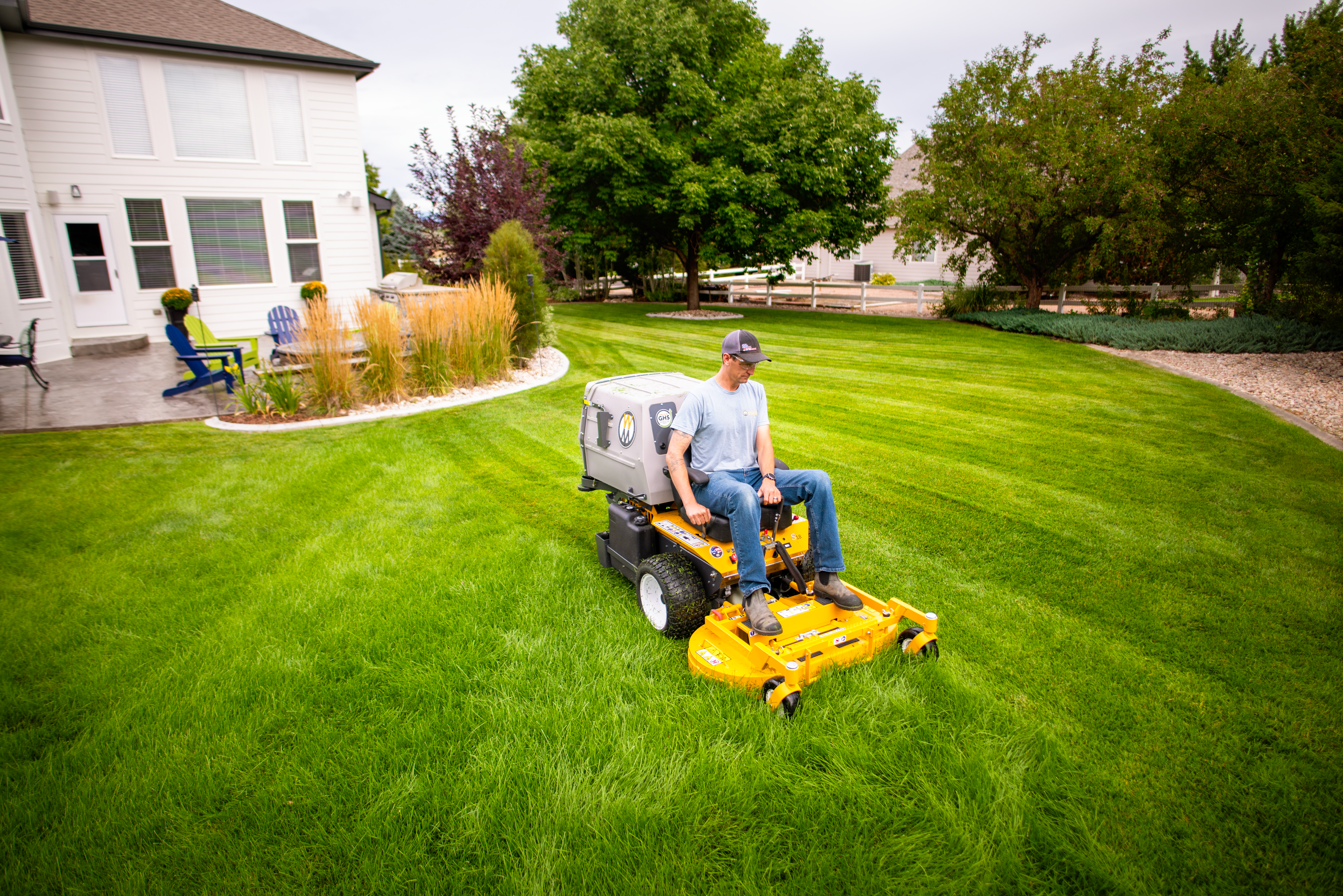 Sit On Mowers Walker S18 With 42-Inch Collection Deck Mowing A Home Lawn